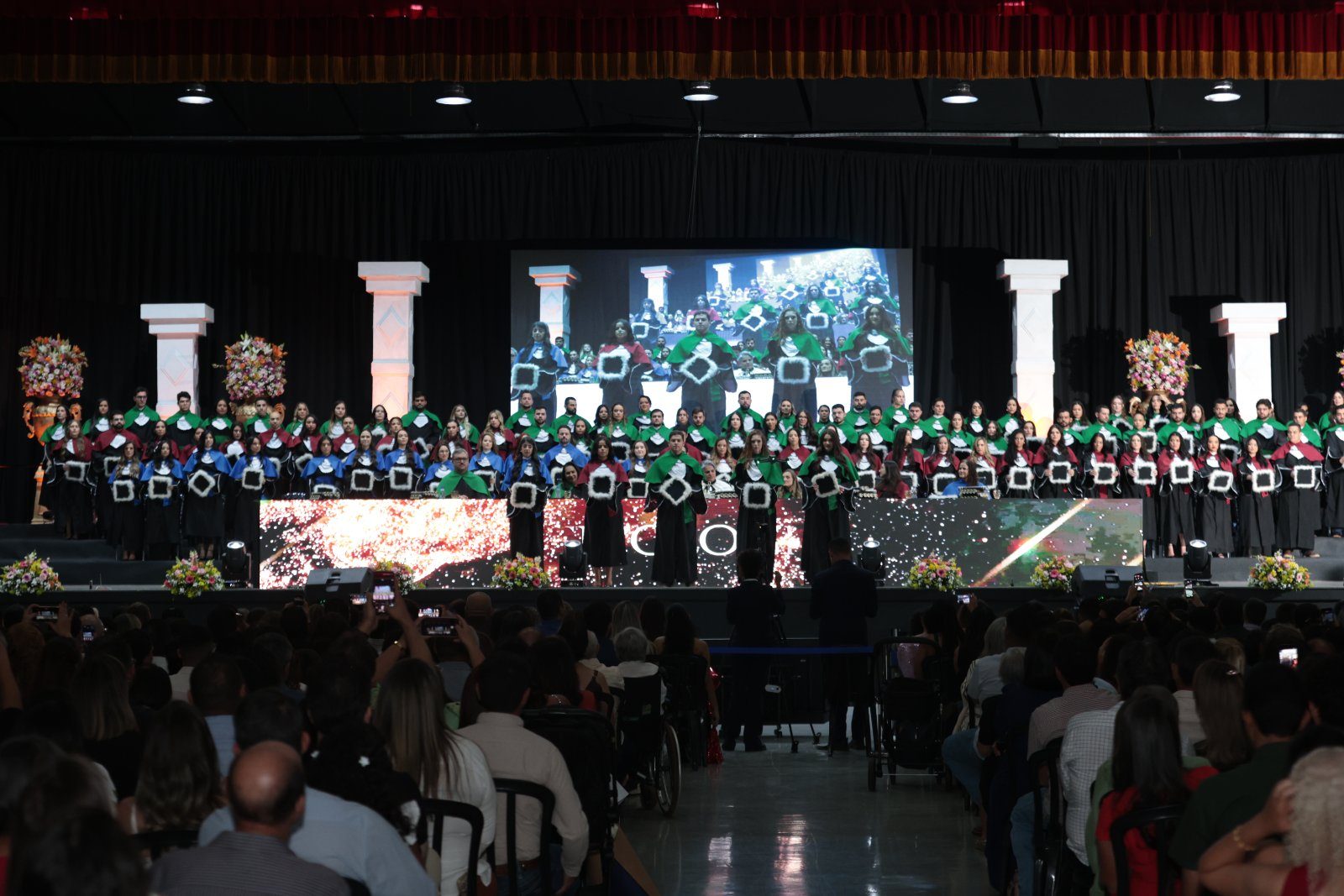 Turma de formandos no palco da colação de grau