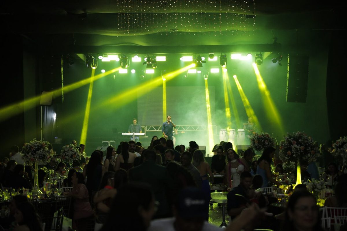 Palco iluminado do baile, com a banda tocando