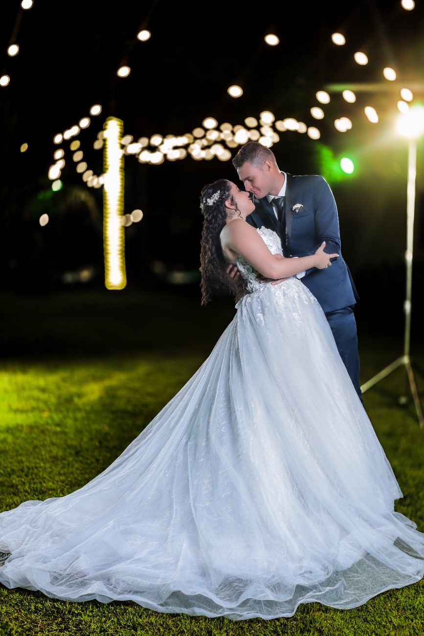 Os noivos sob as luzes do jardim